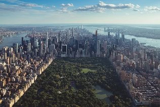 Aerial view of New York City with iconic skyscrapers and Central Park in the foreground.